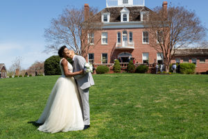 bride and groom kissing in front of Kentlands Mansion